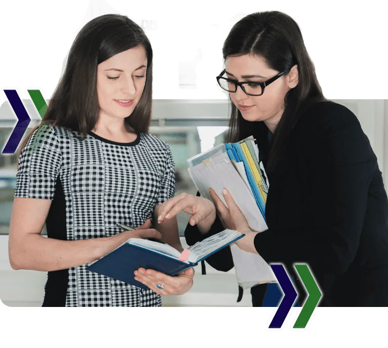 Two women are looking at a book and writing on it, featuring Data Field Technology Services and highlighting their expertise in innovative tech solutions.