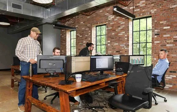 Image of people working in front of a computer, featuring DataField Technology Services and highlighting their expertise in tailored network engineering and design solutions that empower the nation’s largest service providers to achieve success.
